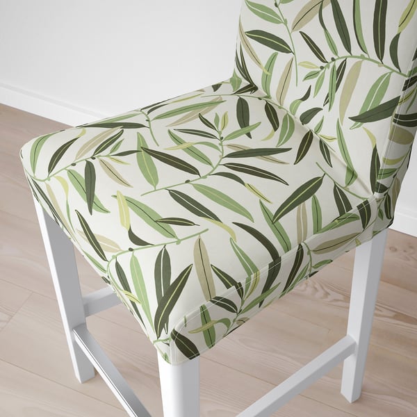 A stylish bar stool with a white frame and a plush, leaf-patterned cushion offering comfort and style.