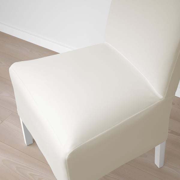 Modern, white upholstered chair with sleek legs, perfect for dining, shown against light wood floor.