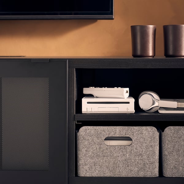 Black BESTÅ tv bench with adjustable shelves and grey felt storage boxes.