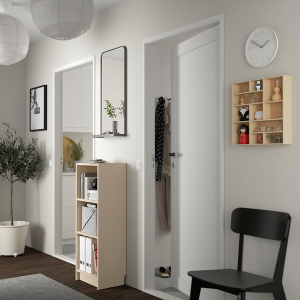 Modern entryway with BILLY bookcase, mirror, shelf, coat, chair, clock, plant, and rug.
