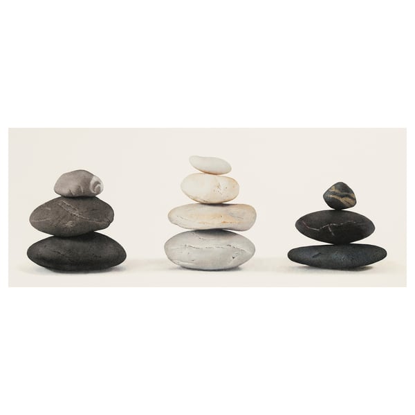 Triptych of balanced stones in black, grey, and white on plain background.
