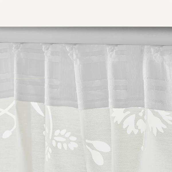 White sheer curtains with leaf patterns, featuring header tabs for easy hanging, allowing privacy while letting daylight through.
