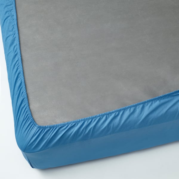 A fitted cotton sheet in blue, stretching over a mattress. Elastic edges secure it in place.
