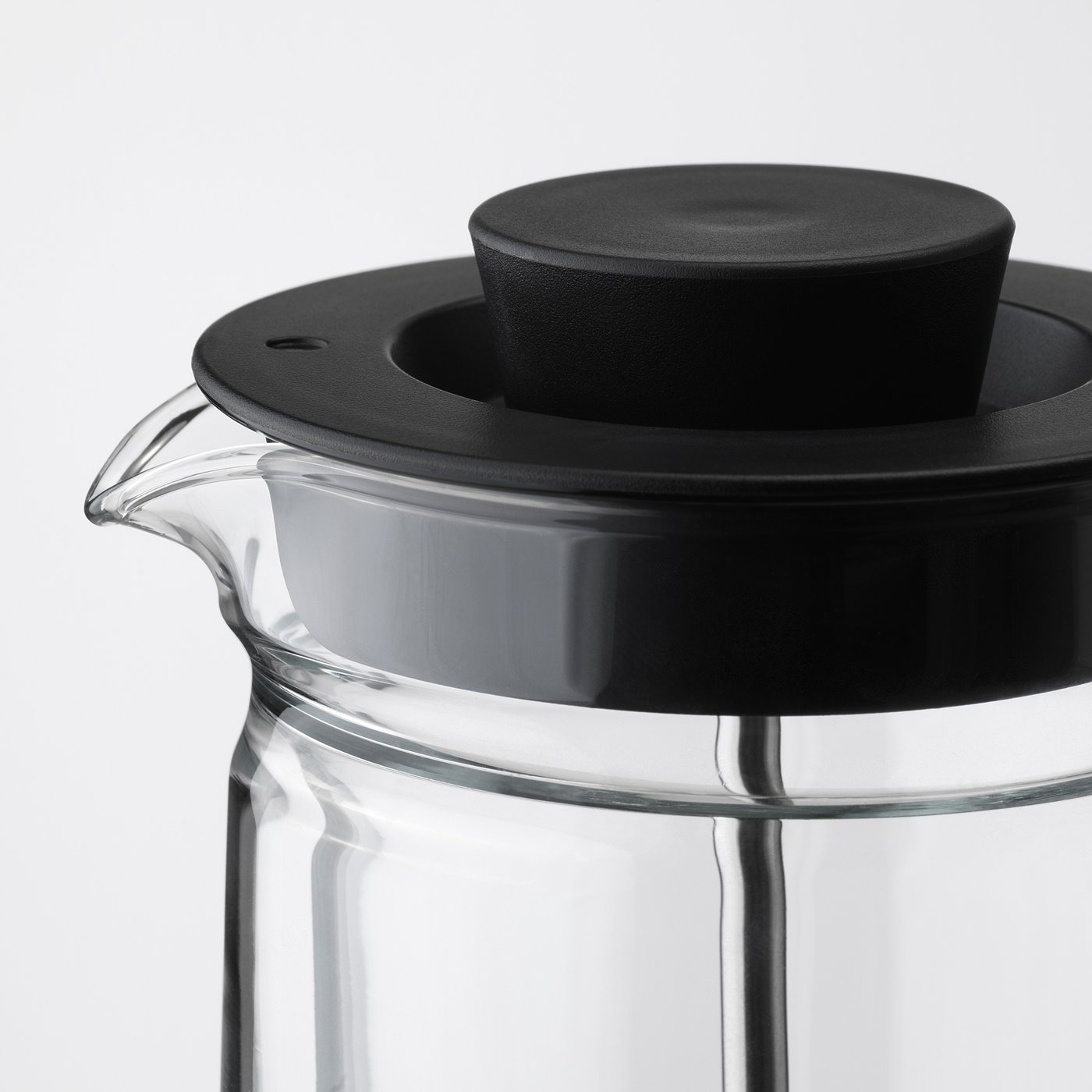 Clear double-walled glass tea maker with black lid and strainer. Sleek, modern design, ensuring safety and insulation.