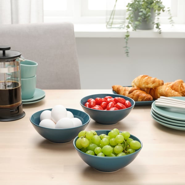Table set with FÄRGKLAR bowls, fresh fruits, pastries, and a cafetière. Perfect for breakfast.