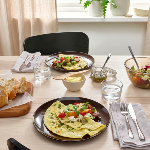 Table set with FÄRGKLAR plates, cutlery, and glasses, topped with gourmet omelettes and bread.