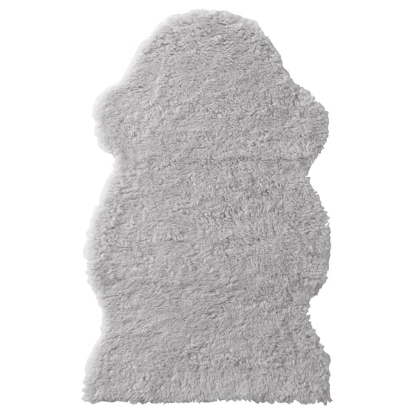 A FÅRDRUP white, shaggy, rectangular rug with soft, fluffy texture, made from recycled and synthetic materials.
