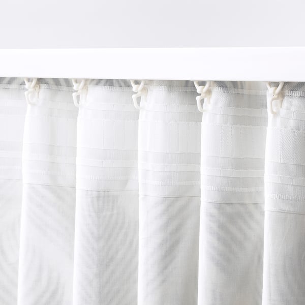 White linen curtains hanging, sheer, slightly textured, privacy and light filtering, tab top mounting.