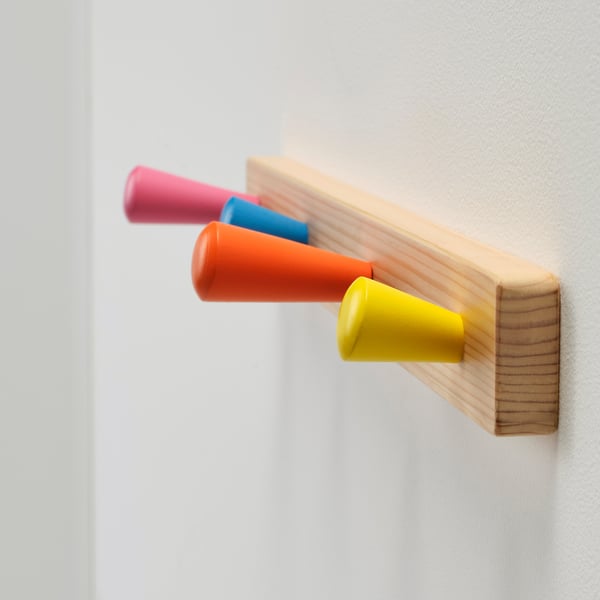 Four colourful hooks on wooden board.