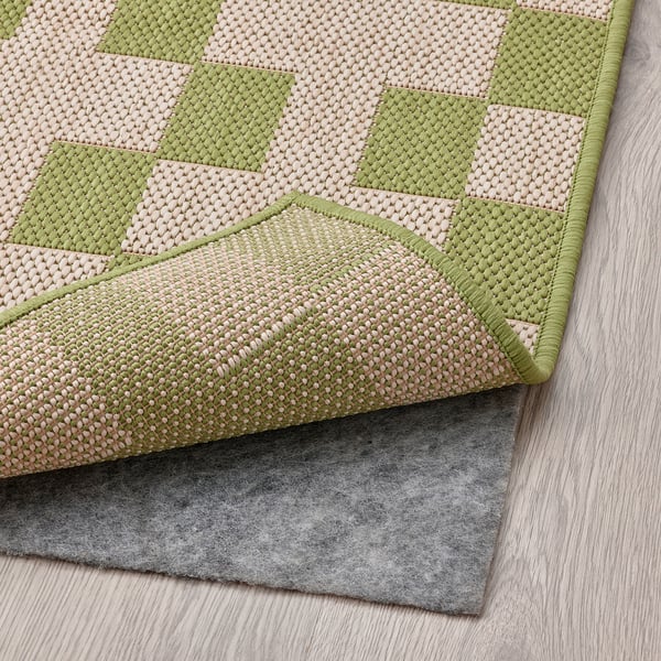 Striped rug on wood floor, grey back.