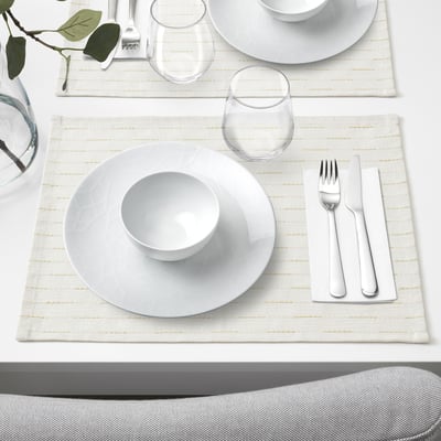 White porcelain table setting with plate, bowl, glass, cutlery, and napkin. Geometric design, arranged neatly.