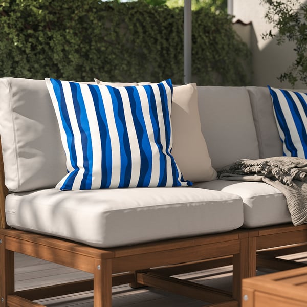 Outdoor patio furniture with white cushions and blue-striped pillows.