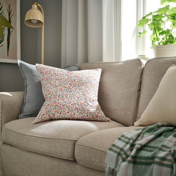 GULLNATTLJUS floral cushion on beige sofa, 100% cotton, cosy decor.