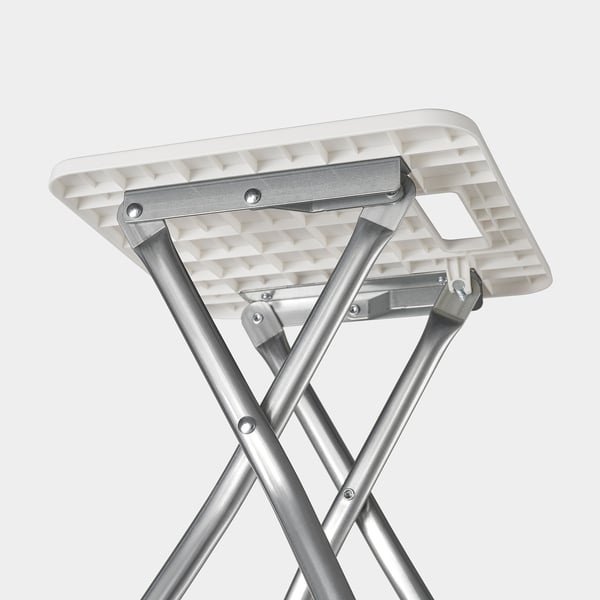 Foldable white stool with metal frame, showing sturdy construction and easy-fold mechanism.