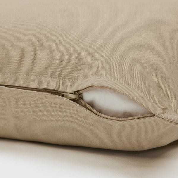 Close-up of tan GURLI cushion with hidden zip for easy removal. Made of durable cotton for comfort.