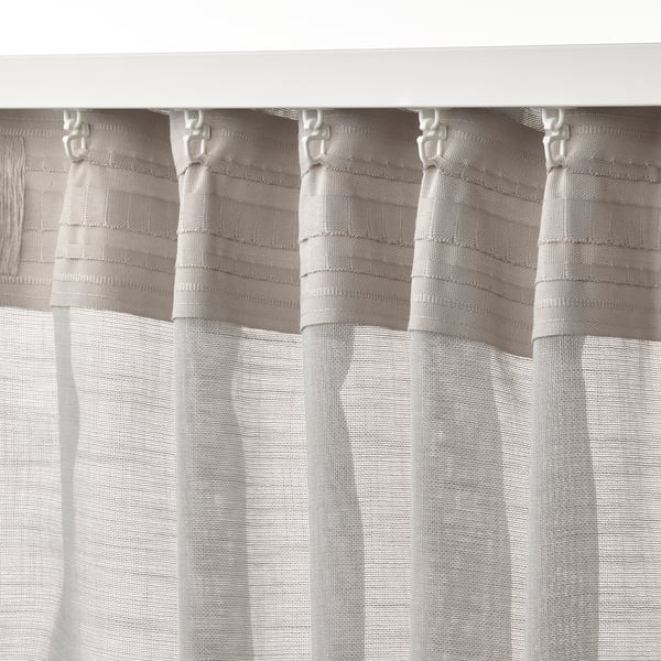 Light grey HÄLLEBRÄCKA sheer curtains with pleated design, allowing daylight while maintaining privacy, hanging neatly from curtain rod using hooks.