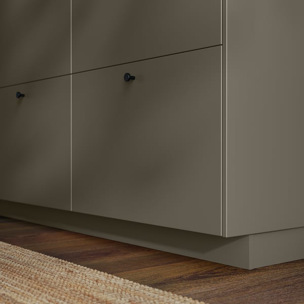 Low kitchen cabinets in dark grey with blue handles on wood floor.
