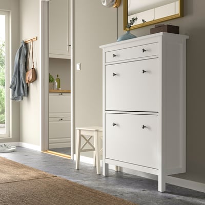 White HEMNES shoe cabinet, tall, in entryway, next to coat hooks and stool.