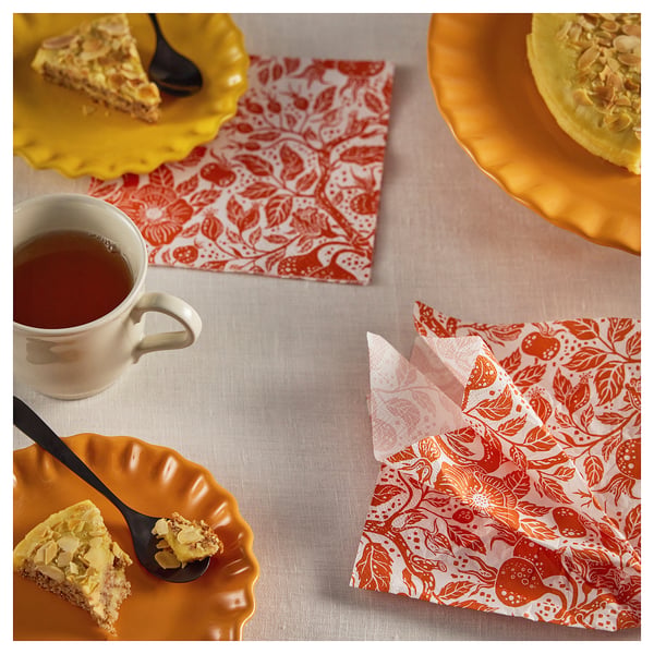 Orange dessert plates, tea mug, floral napkins, and spoons from HÖSTAGILLE collection.