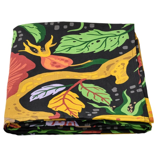HÖSTAGILLE tablecloth, black with vibrant green, yellow, and red leaf patterns, rectangular, made of 100% cotton.