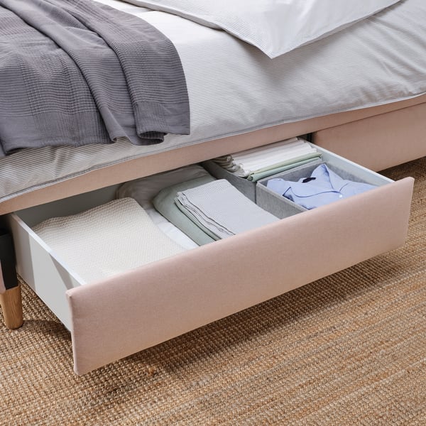 Neatly organised bed drawers with folded blankets, showcasing under-bed storage.