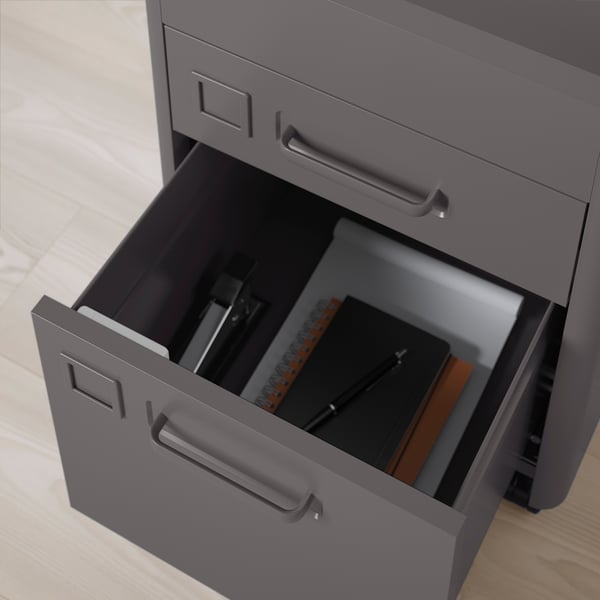 Grey desk drawer with smart lock, holding notebooks and tools.