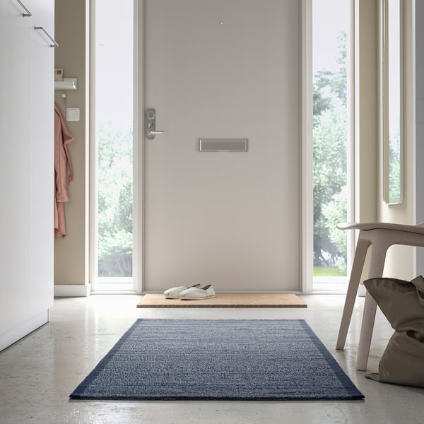Blue IDROTTSPLATS rug near door, under mat and chair.