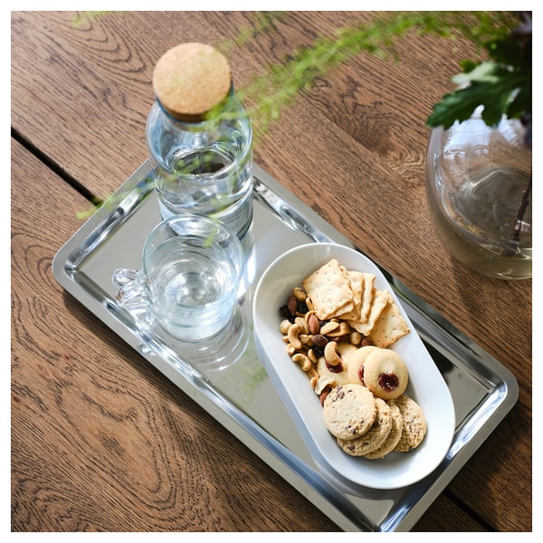 Tray with plate holds snacks and drinks. Set includes water bottle, two glasses, dish with crackers and nuts. Ideal for serving and sharing.