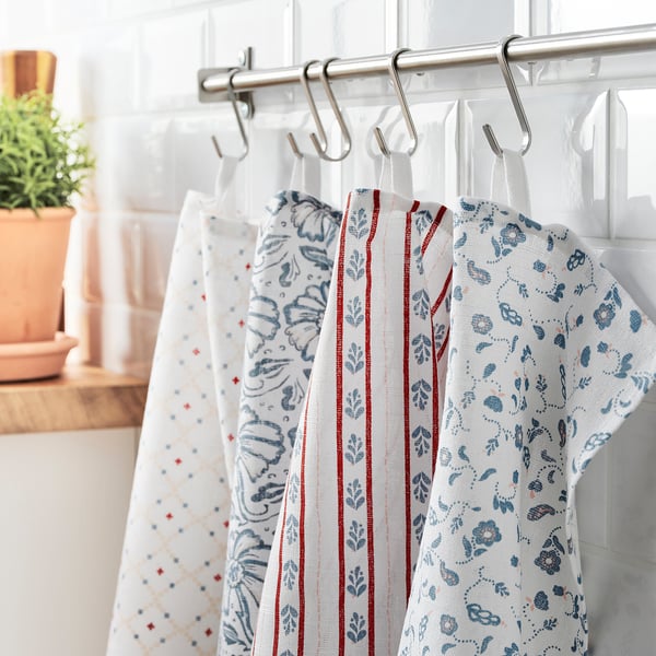 Three hanging dish towels with blue floral patterns on a kitchen rod.