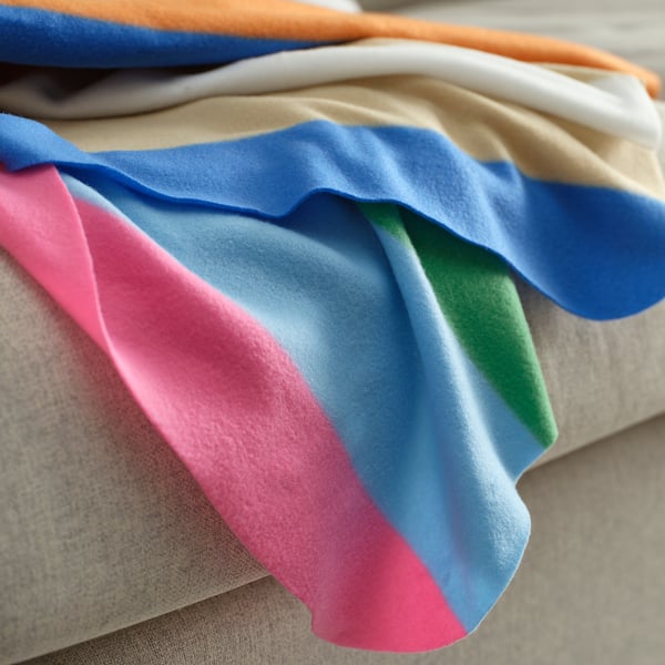 Brightly coloured striped cloth with soft texture, neatly folded, showcasing vibrant design.