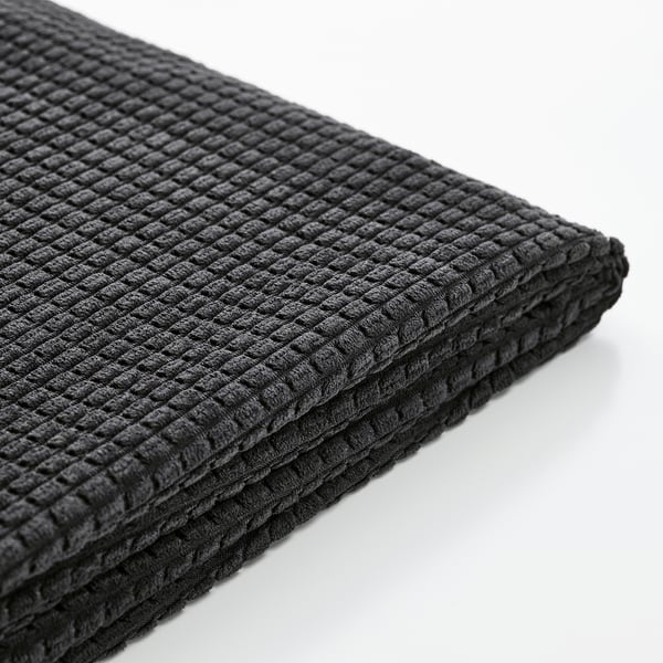 Close-up of folded black textured fabric, showcasing its quality texture and stitching.