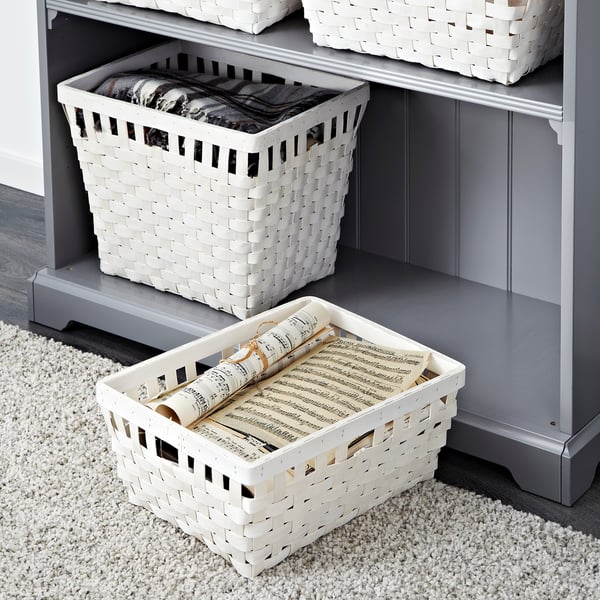 White woven baskets organising items in and out of a grey shelf.