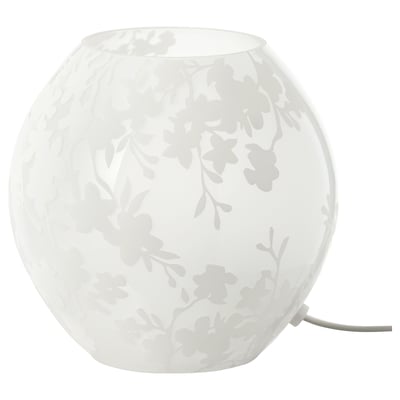 The KNUBBIG lamp, white, made of glass with painted cherry blossom design, spherical shape, emits soft mood light.