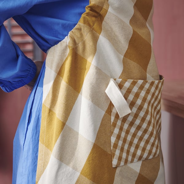 Apron with large chequered squares, pocket, and adjustable strap. Perfect for cooking, with a hanging loop.