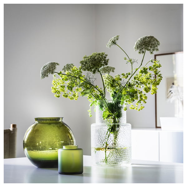 Image KONSTFULL glass vase in green, holding white flowers, beside two more green vases.
