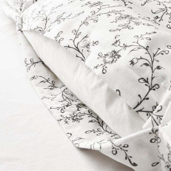 White duvet cover with black floral pattern and hidden snap closures for secure fit.