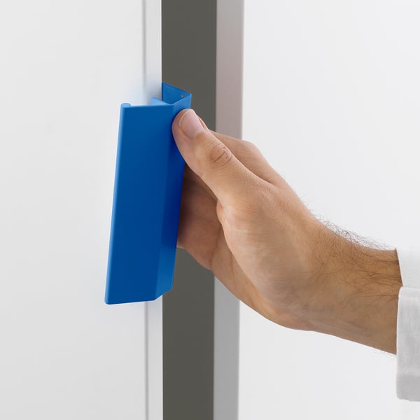 A hand attaches a blue handle to a grey drawer, demonstrating the easy-clamp function of LÄTTHET handles, ideal for platsa storage.