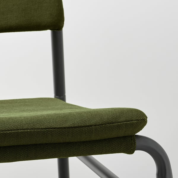 A close-up of a green upholstered chair with a robust metal frame, highlighting its quality and comfort.