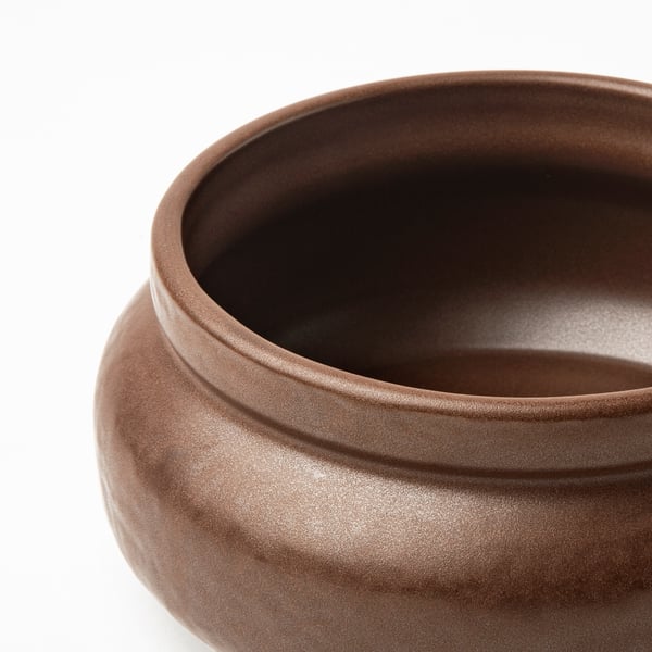 Close-up of handcrafted bowl with smooth, earthy glaze. Wide, shallow design, revealing detailed craftsmanship.
