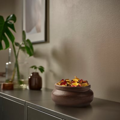 Earthy brown stoneware MÄVINN bowl on black table, minimalist design.