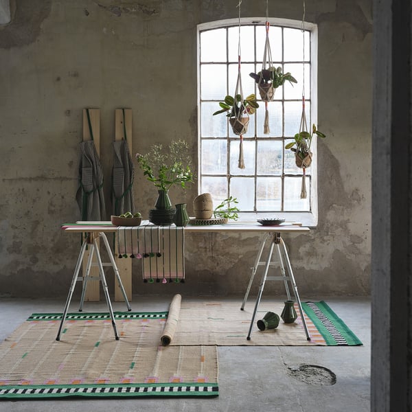 Macramé plant hangers and decor in rustic, cosy room with large windows.