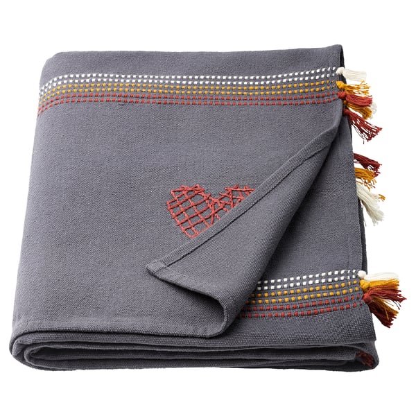 Grey embroidered cotton throw with red heart, tassels, and geometric border.