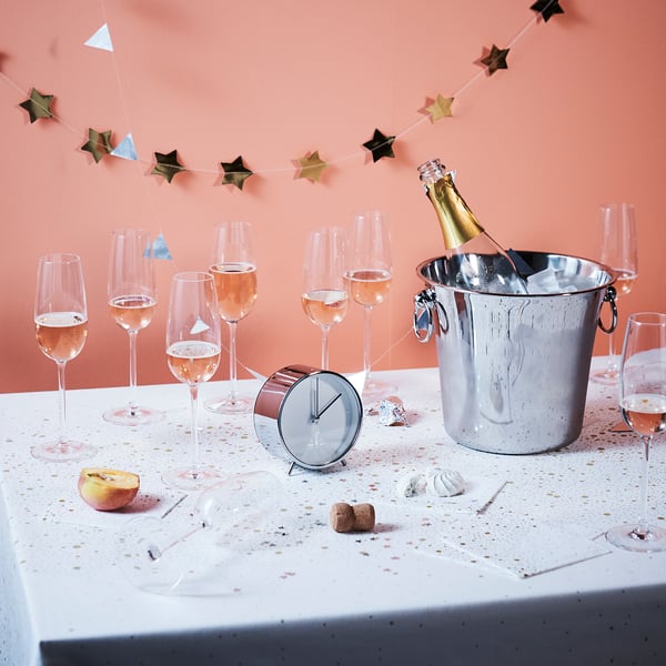 Silver MALLHOPPA clock on table with wine & glasses.