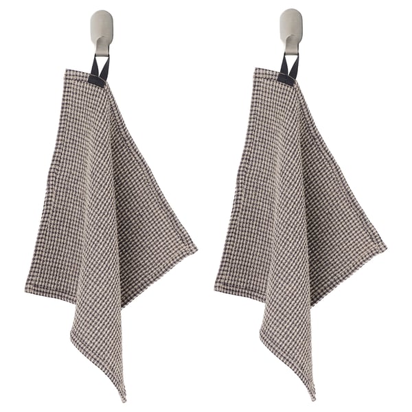 Two houndstooth kitchen towels hang from metal hooks, black loops at top, beige and black chequered pattern.