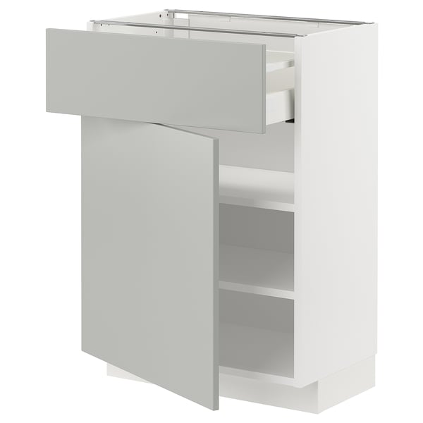 A white METOD kitchen cabinet with a light grey drawer and shelf, featuring a modern and clean design.