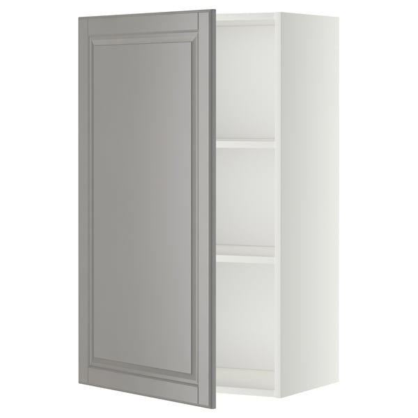 A white METOD kitchen cabinet with a grey door featuring bevelled edges. The design is traditional, with a wooden frame and adjustable shelves.