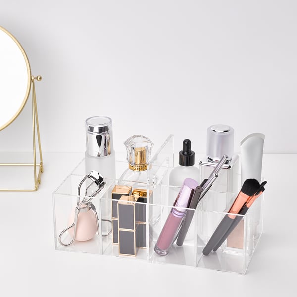 Clear acrylic makeup organiser with multiple compartments. Holds brushes, eye tools, and cosmetics. Includes a sturdy carry handle.