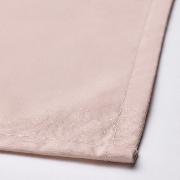 Close-up of a soft, pink fabric napkin with neat stitching and a smooth texture.