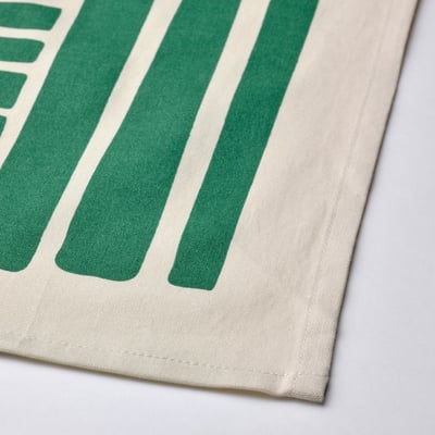 Green and white striped fabric corner, showing soft, even stitching and textured cotton.
