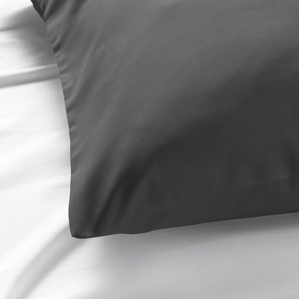 Smooth, dark grey pillowcase displayed on white bedding, showcasing its luxurious, soft texture.